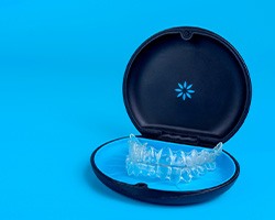 Invisalign trays in carrying case with light blue background