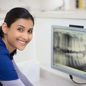 Dental assistant looking at digital x-rays