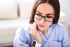 Woman holding jaw in pain