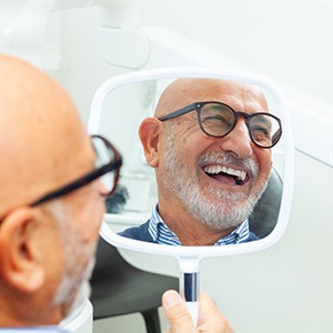 A man looking in the mirror at his smile