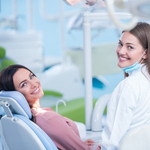 Both a female patient and dentist smiling