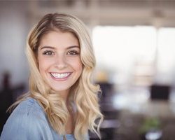 young woman smiles after getting dental implants in Carrollton