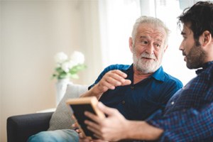 An older father talking to his adult son