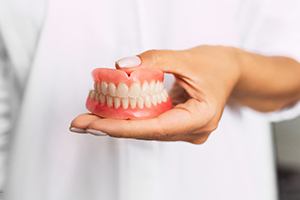 Dentist holding full dentures.