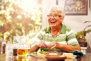 Senior woman eating lunch with dentures