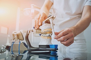 a dental lab technician using an articulator