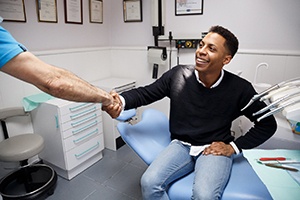 Man shaking dentist hand after treatment for toothache in Carrollton