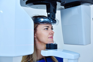 A woman using a cone beam scanner for dental images