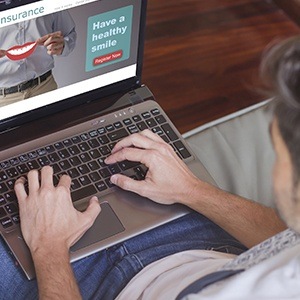 Man looking at dental insurance on laptop