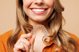Woman holding an Invisalign aligner 