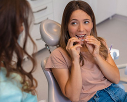 Dentist talking to female patient about Invisalign wear 