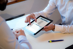 Two people looking at digital tablet with dental insurance displayed
