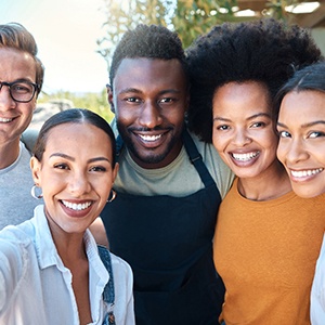 a group of friends smiling and taking a selfie together