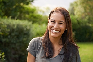 a smiling person standing in a park