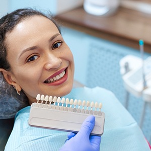 a dentist matching the color of a patient’s teeth