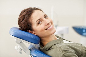 Female dental patient leaning back after root canal therapy in Carrolton, TX