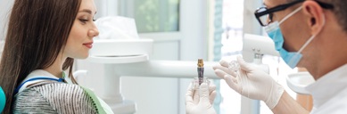 Dentist showing woman a dental implant