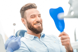 Man looking at smile in mirror