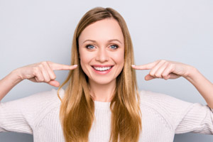 Woman pointing to her beautiful smile