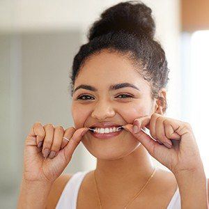 Woman flossing teeth