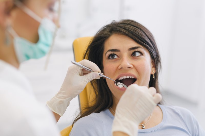 a woman having her teeth checked by the dentist