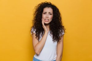 young woman with mouth pain needs emergency dentist in Carrollton