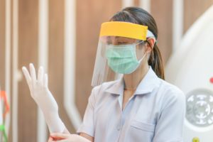 dentist in Carrollton putting on PPE before treating a patient