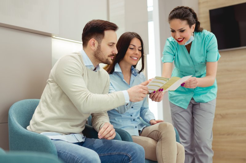 Couple discussing benefits with dental staff member