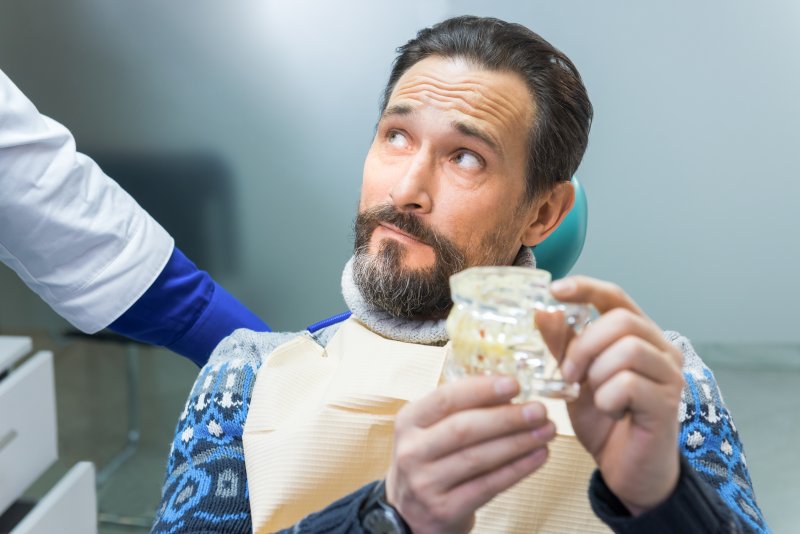 Man listening to dentist during implant consultation in Carrollton