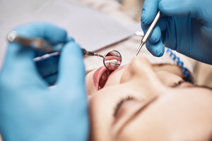 Close-up of a woman having teeth examined by a dentist