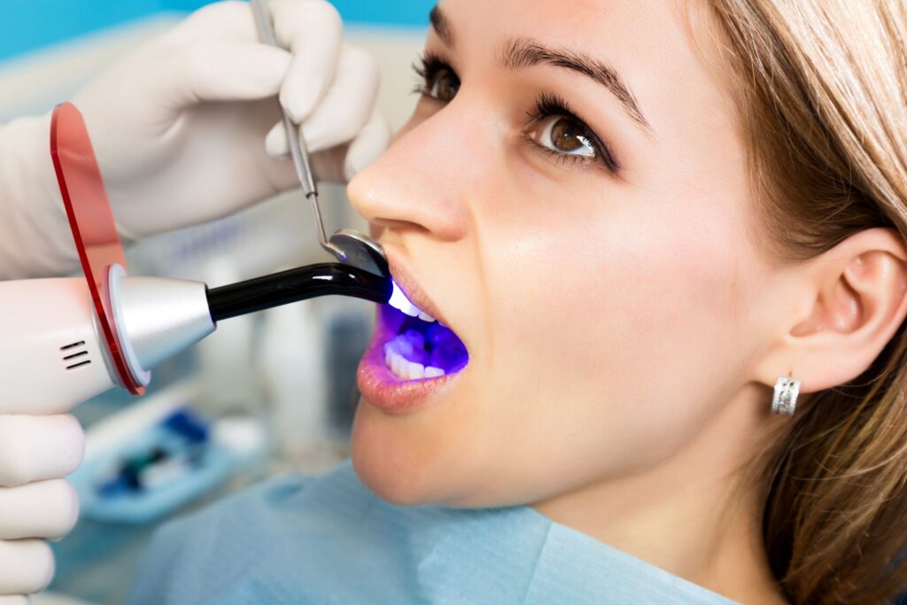 Closeup of woman undergoing dental bonding procedure at dental office